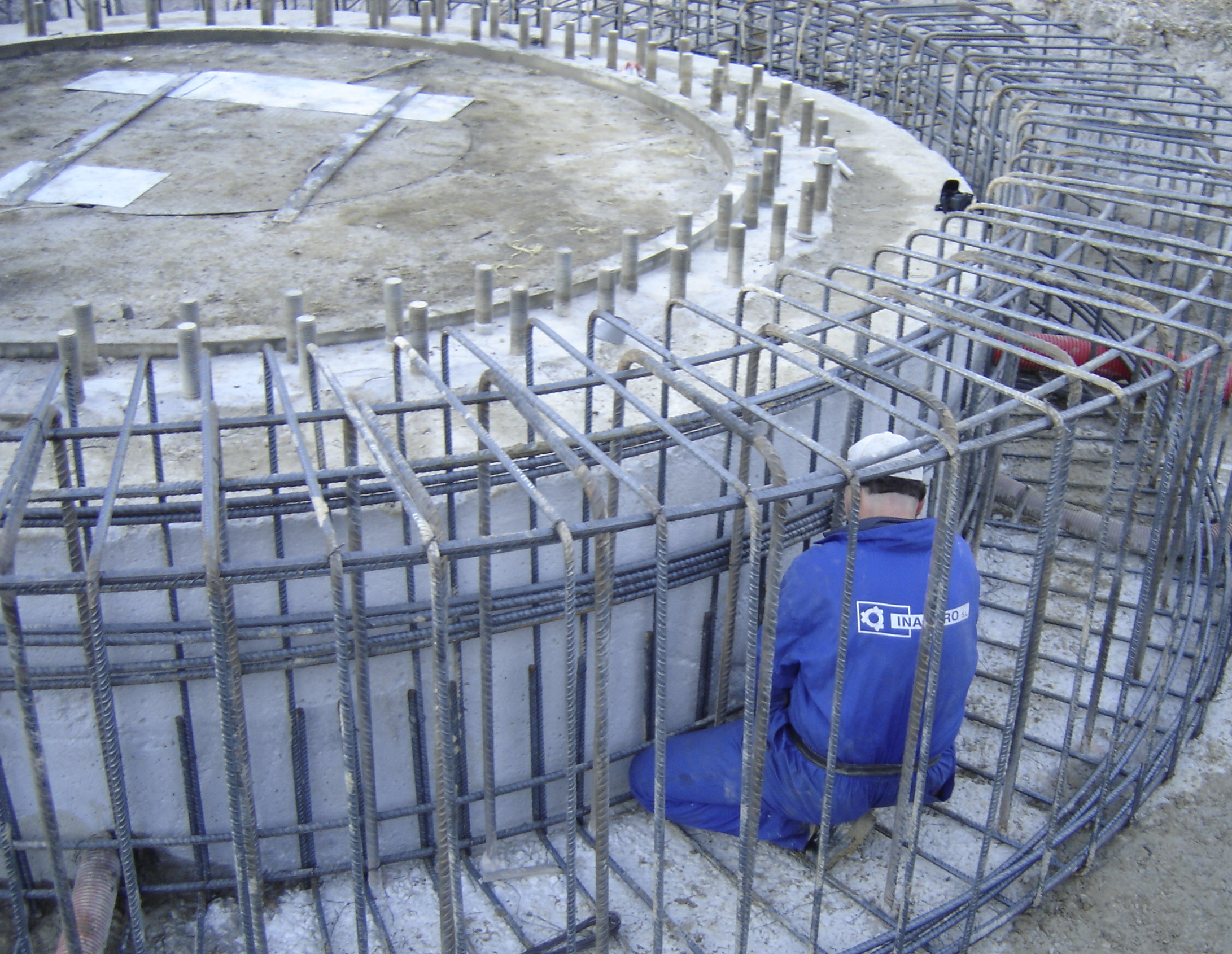 Operario trabajando en obra con forma circular con estructura de acero